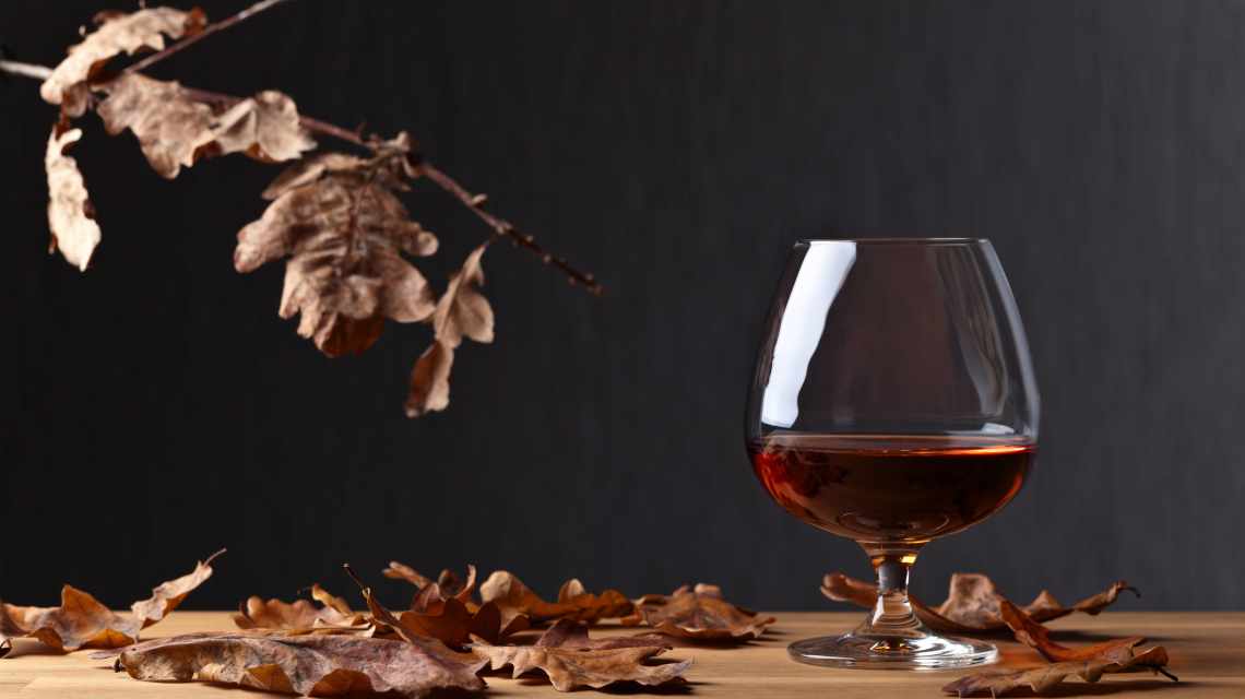 Snifter of brandy and dried oak leaves